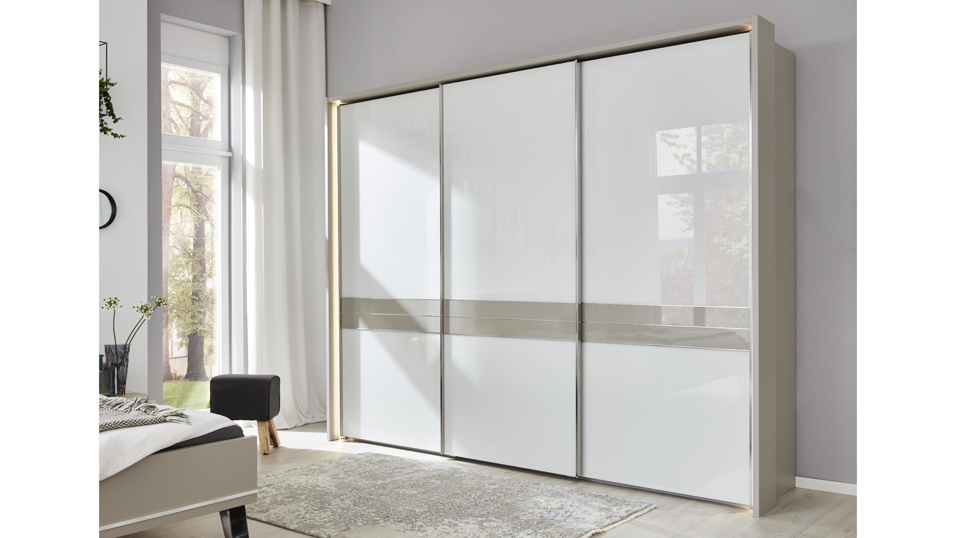 Kleiderschrank Wiemann oeseder | il aus Holz in Weiß Interliving Schlafzimmer Serie 1009 – Schwebetürenschrank weiße Glas- & kieselgraue Kunststoffoberflächen – drei Türen