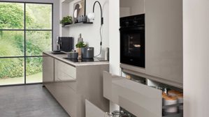 Einbauküche Nobilia® aus Holz in Grau nobilia® Einbauküche Novalux mit Hochglanzfronten und BORA Muldenlüfter Taupegrau & Eiche Como - zweiteilig