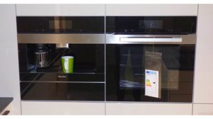 Einbauküche WERT KÜCHE® aus Holz Nachbildung Stein in Weiß Schwarz WERT KÜCHE Gala Musterküche mit Miele Einbaugeräten Muschelweiss & Naturstein schwarz