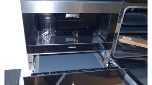 Einbauküche WERT KÜCHE® aus Holz Nachbildung Stein in Weiß Schwarz WERT KÜCHE Gala Musterküche mit Miele Einbaugeräten Muschelweiss & Naturstein schwarz