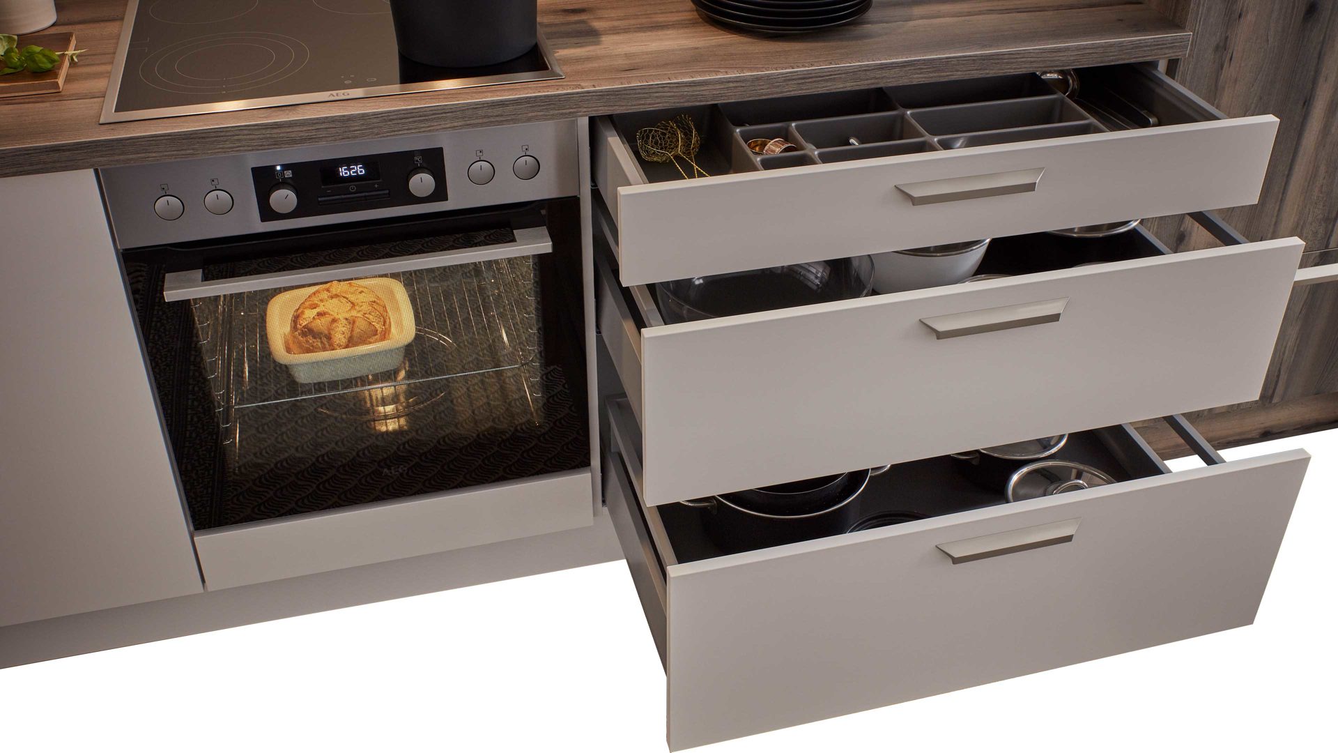 Einbauküche WERT KÜCHE® aus Holz in Beige WERT KÜCHE® Nora mit AEG Einbaugeräten Muschelweiß & Virginia Eiche – zweizeilig