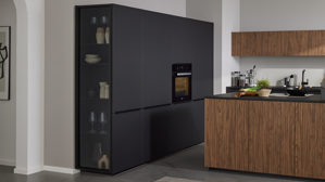 Einbauküche Interliving aus Holz in Schwarz Interliving Küche Serie 3076 mit Miele-Einbaugeräten Mattschwarz & Stripe Wood Choco - dreizeilig