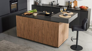Einbauküche Interliving aus Holz in Schwarz Interliving Küche Serie 3108 mit Miele-Einbaugeräten Mattschwarz & Stripe Wood Choco - dreizeilig