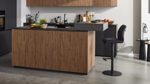 Einbauküche Interliving aus Holz in Schwarz Interliving Küche Serie 3108 mit Miele-Einbaugeräten Mattschwarz & Stripe Wood Choco - dreizeilig