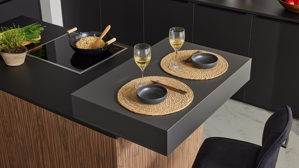 Einbauküche Interliving aus Holz in Schwarz Interliving Küche Serie 3076 mit Miele-Einbaugeräten Mattschwarz & Stripe Wood Choco - dreizeilig