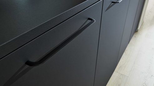 Einbauküche Interliving aus Holz in Schwarz Interliving Küche Serie 3055 mit AEG Einbaugeräten Mattschwarz & Vulkaneiche  - dreizeilig