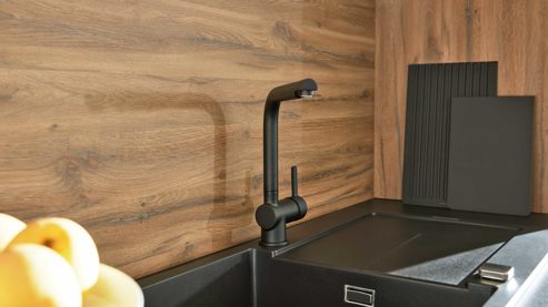 Einbauküche Interliving aus Holz in Schwarz Interliving Küche Serie 3055 mit AEG Einbaugeräten Mattschwarz & Vulkaneiche  - dreizeilig