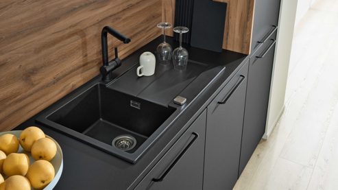 Einbauküche Interliving aus Holz in Schwarz Interliving Küche Serie 3103 mit AEG Einbaugeräten Mattschwarz & Vulkaneiche  - dreizeilig