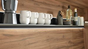 Einbauküche Interliving aus Holz in Schwarz Interliving Küche Serie 3055 mit AEG Einbaugeräten Mattschwarz & Vulkaneiche  - dreizeilig