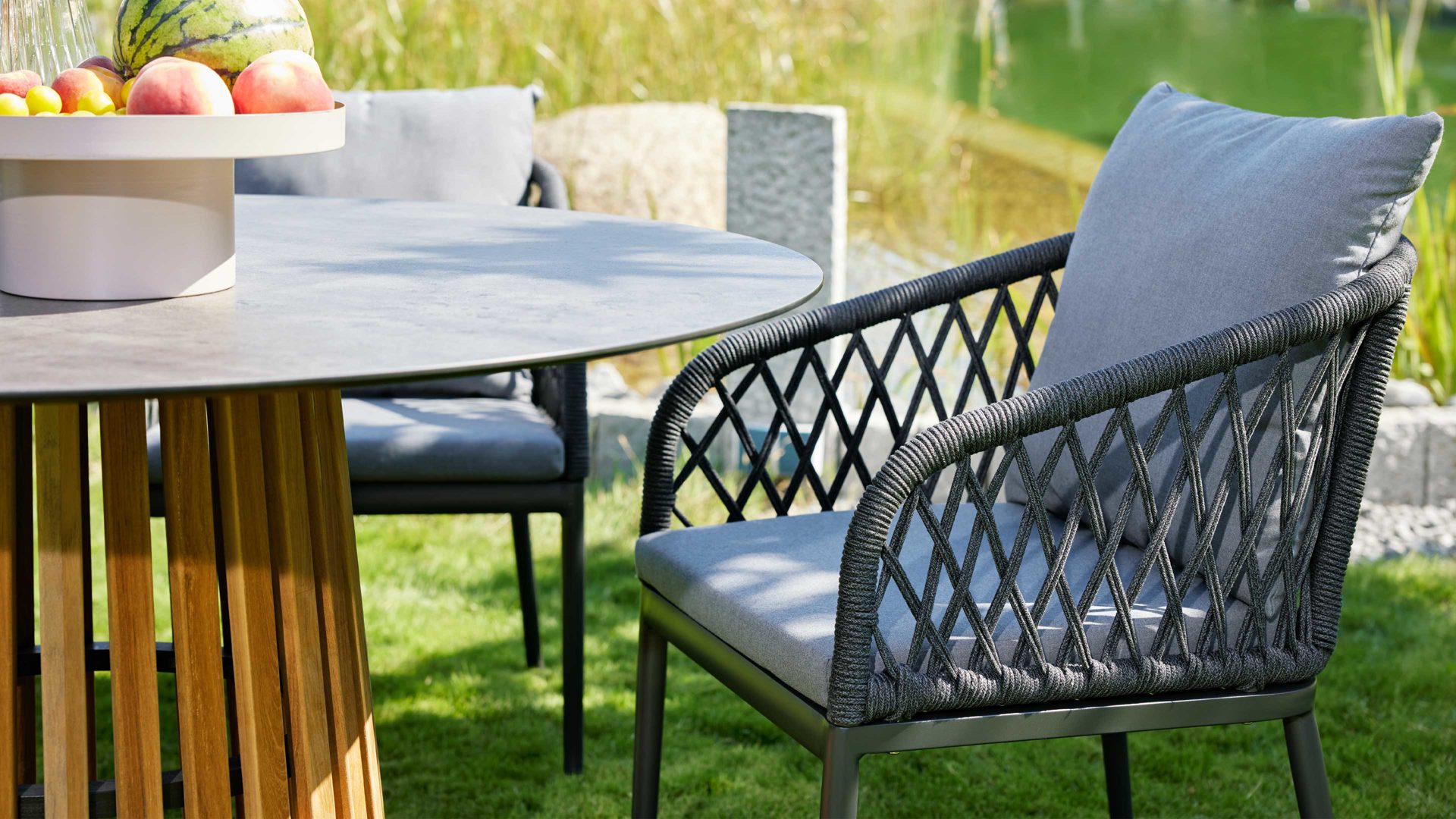 Gartenmöbel-Set Interliving aus Geflecht in Grau Interliving Gartenmöbel Serie 7004 – Tischgruppe mit rundem Tisch graues Kordelgeflecht & dunkelgrauer Bezug Heather 181, HPL Beton & Teakholz