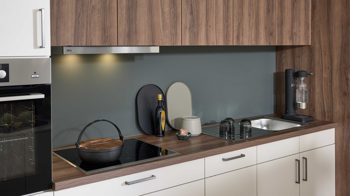 Einbauküche WERT KÜCHE® aus Holz in Weiß WERT KÜCHE® Nora mit AEG Einbaugeräten Muschelweiß & Victoria Nussbaum - zweizeilig